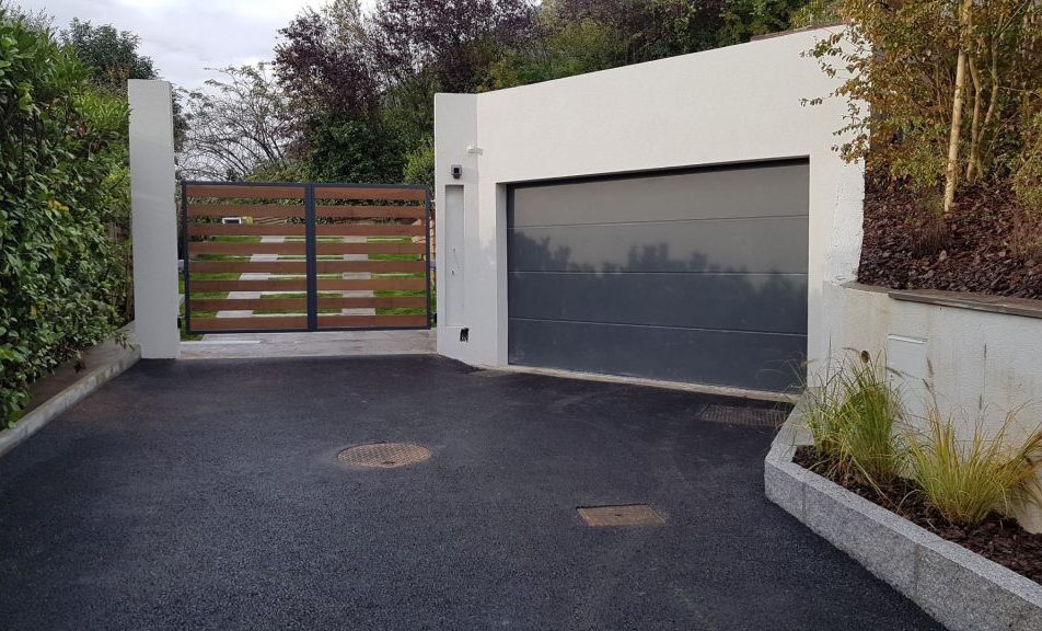 Portail mixte en bois aluminium à gauche d'une porte de garage